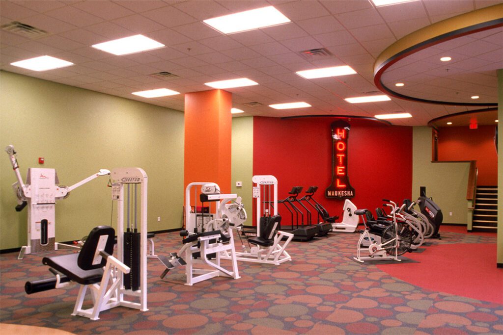 Brightly lit fitness center at Avalon Square showing treadmills, stationary bikes and weight machines.