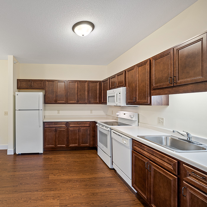 Kitchen with dark cabinets and white appliances.