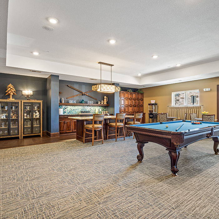 Pub room with a billiard table and bar seating.