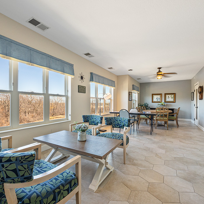 Bright, spacious puzzle room with a wall of windows and tables and chairs.