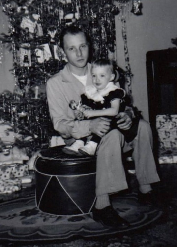 Monica as a small child, sitting on her dad's lap years ago