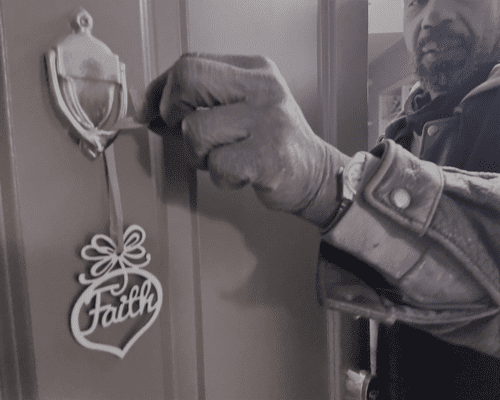 Willie hangs a faith ornament on his front door
