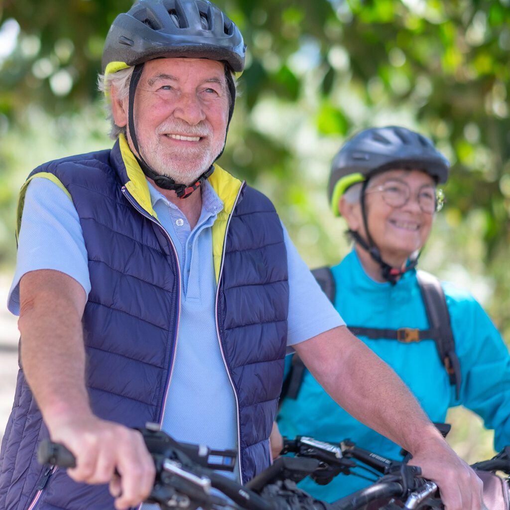 Happy, active couple bike while wearing helmets.