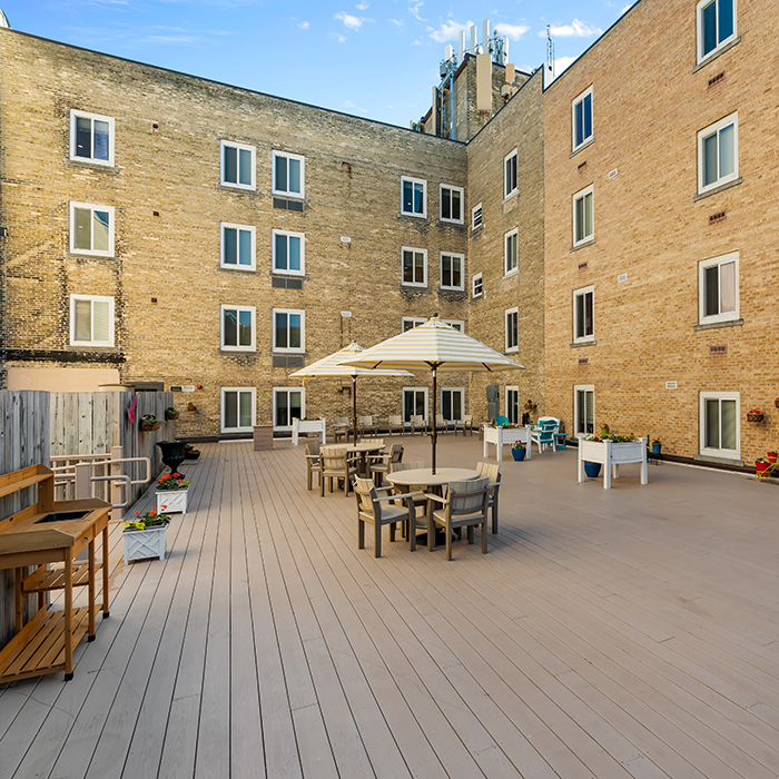 Patio tables and chairs with umbrellas in the courtyard.